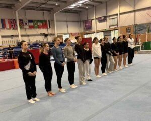 women artistic gymnasts in training line up